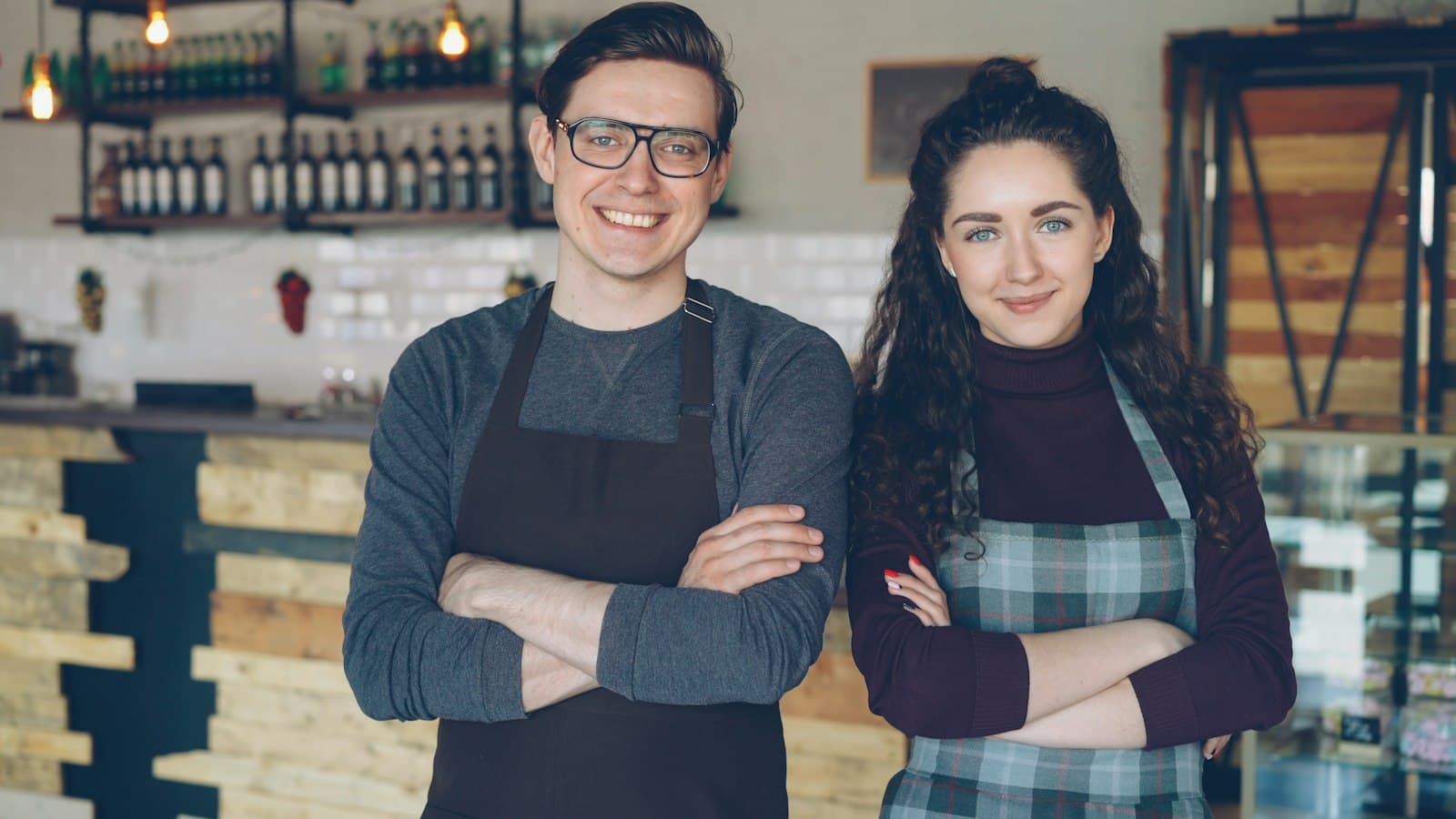 Two café owners standing proudly together behind their counter