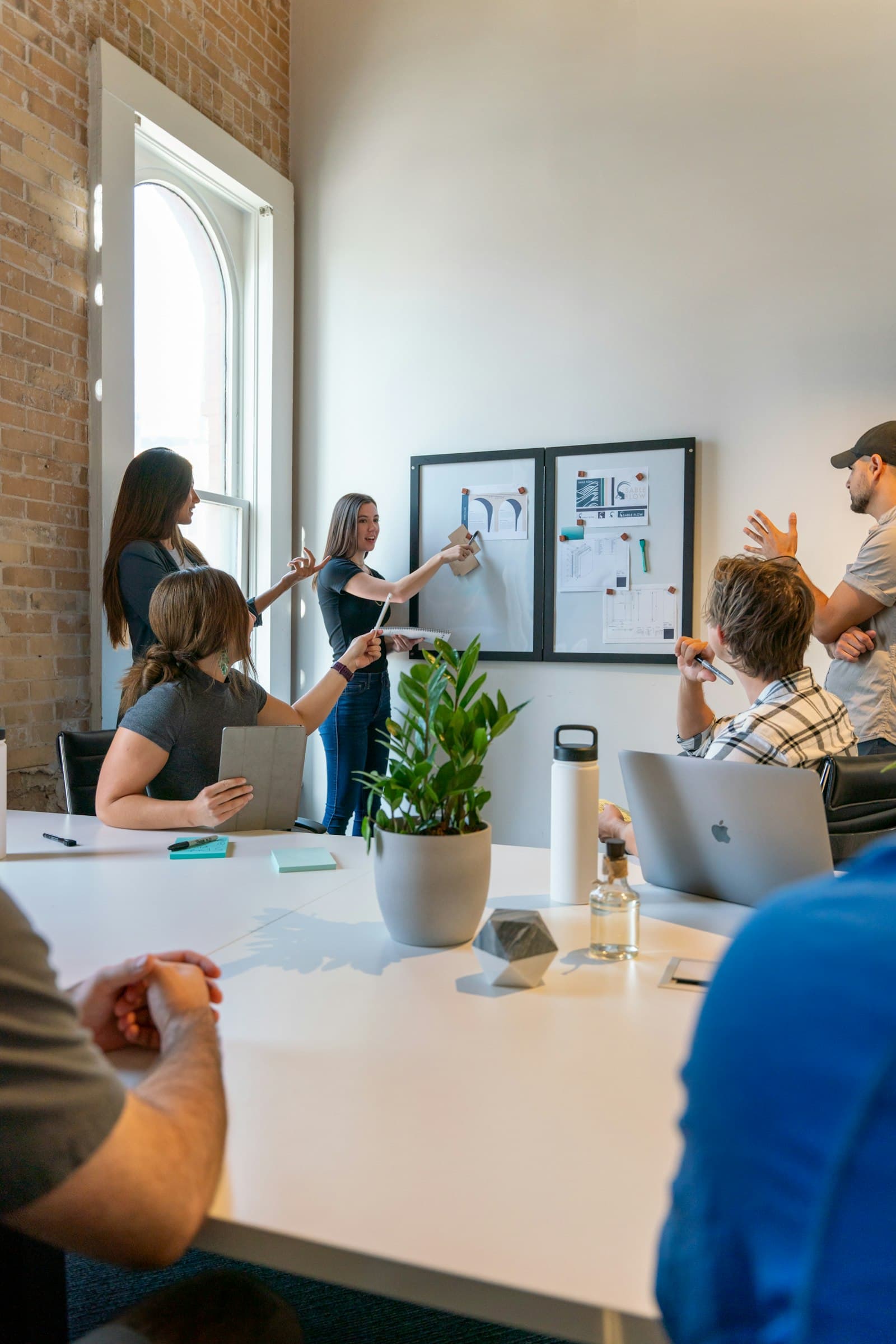 A small team planning at a whiteboard in a bright studio
